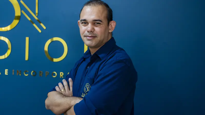 Consultora da Sadion fazendo sinal de positivo em frente ao logotipo