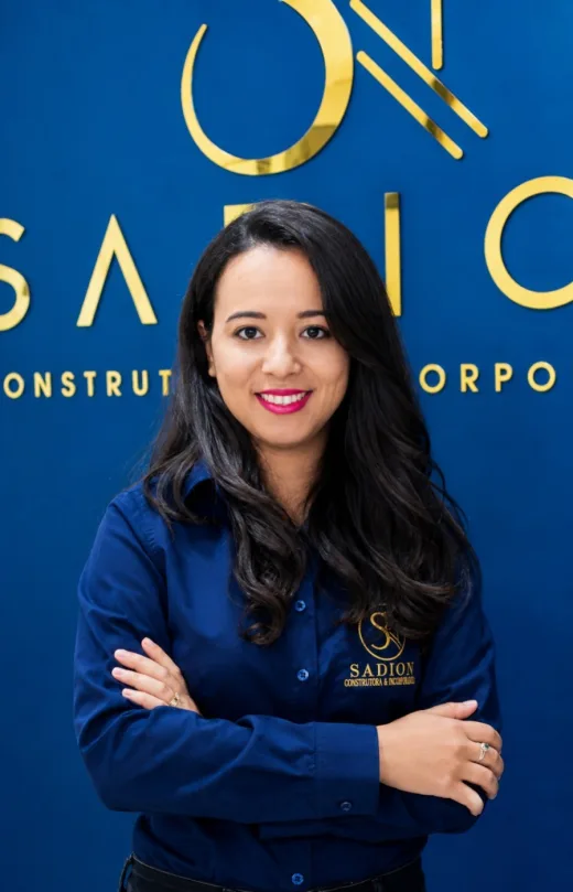 Integrante da equipe Sadion em frente ao logotipo da empresa