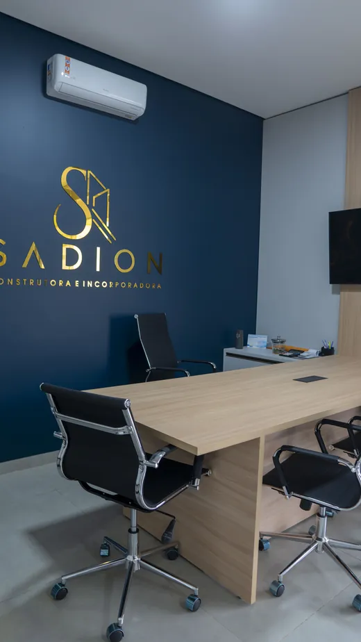 Sala de reunião da Sadion com logotipo dourado na parede